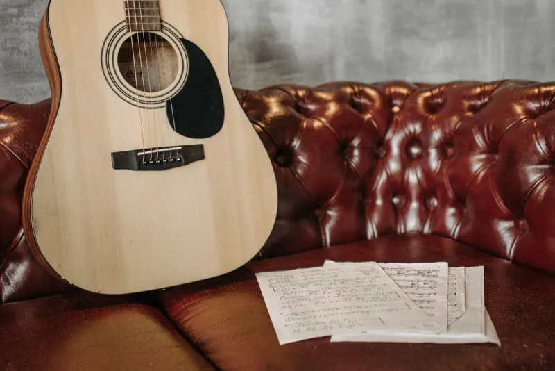 A beginner's hands learning basic guitar chord positions on the fretboard, showing that no prior experience is needed