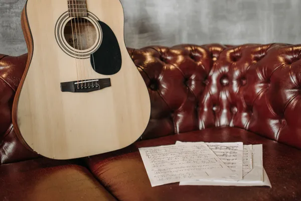A beginner's hands learning basic guitar chord positions on the fretboard, showing that no prior experience is needed