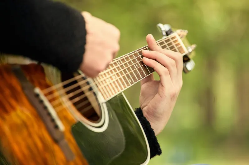 A steel-string acoustic guitar suited for fingerstyle playing, with a narrower fretboard and steel strings